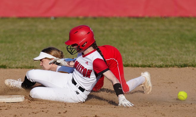 Sussex Hamilton's Lauren Bickler, foreground, slides safely into second as Divine Savior Holy Angels' Tessa Grogan (1) takes a fall at Hamilton on Tuesday, April 9, 2024.